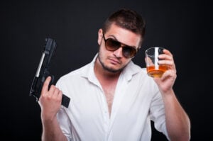 Armed murderer rising up a glass of liqueur
